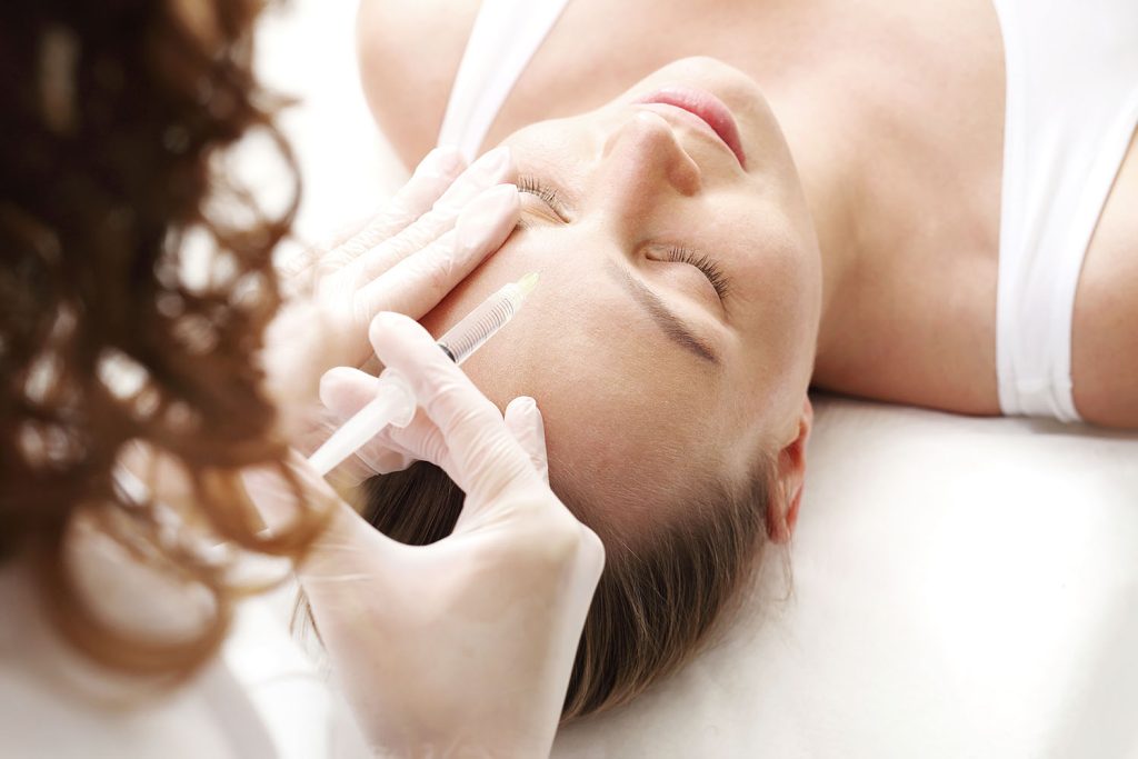 An injectable treatment is administered to the forehead, a common method in aesthetic medicine to improve skin quality and appearance.